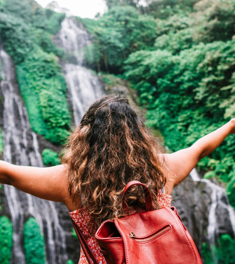 female hiking in front of a waterfall